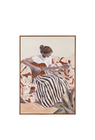 A framed oil painting of a woman with her hair in a bun, seen from behind, playing a guitar while seated in a floral armchair, wearing a white blouse and black and white striped skirt, with a green agave plant in the foreground.